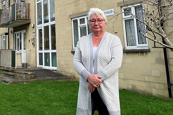 Ruth standing in front of a block of flats